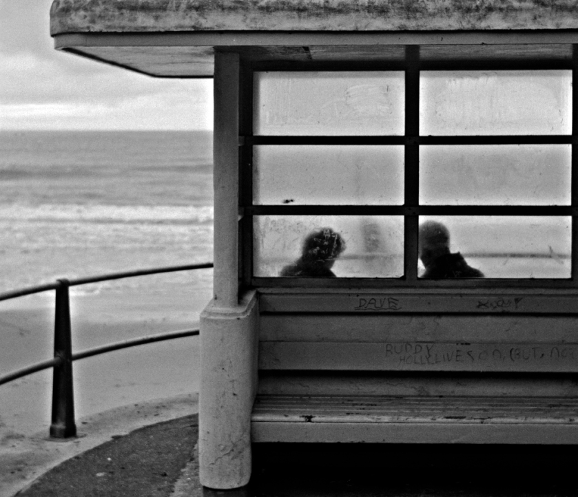 Beach shelter, couple talking in silhouette.